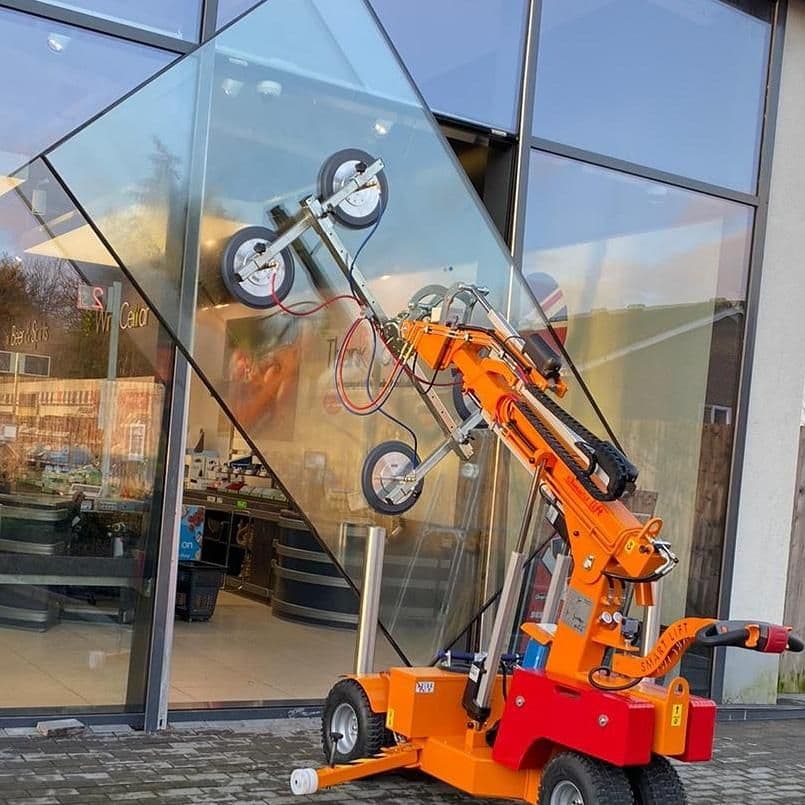 SL608 outdoor moves and lifts a large glass panel for a storefront